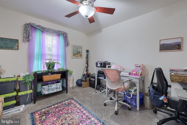 carpeted home office featuring ceiling fan