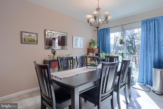 dining space with light tile patterned floors, baseboards, and a chandelier