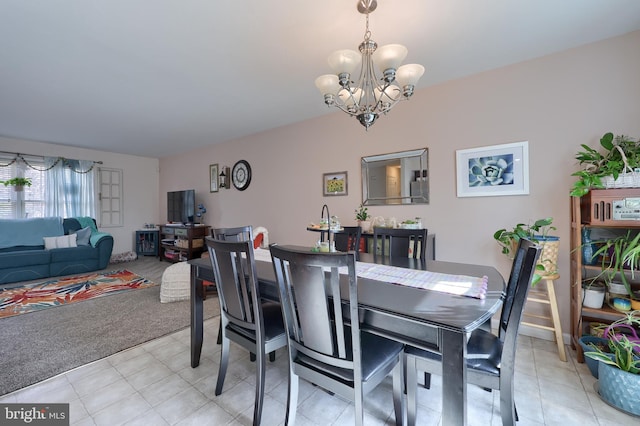 dining space featuring a notable chandelier, light tile patterned floors, and light carpet