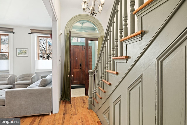 entryway with a chandelier, stairway, and light wood-type flooring