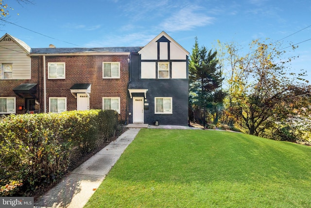 view of front of property featuring a front yard and brick siding