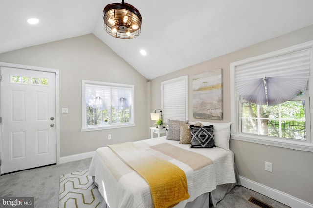 bedroom featuring light colored carpet, multiple windows, vaulted ceiling, and baseboards