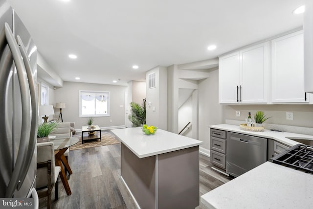 kitchen with recessed lighting, stainless steel appliances, dark wood-type flooring, white cabinetry, and open floor plan