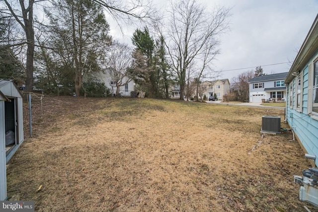 view of yard with a residential view and central AC