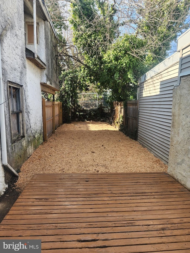 wooden terrace with a fenced backyard