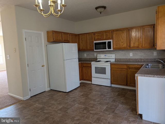 kitchen featuring a chandelier, white appliances, a sink, backsplash, and brown cabinets