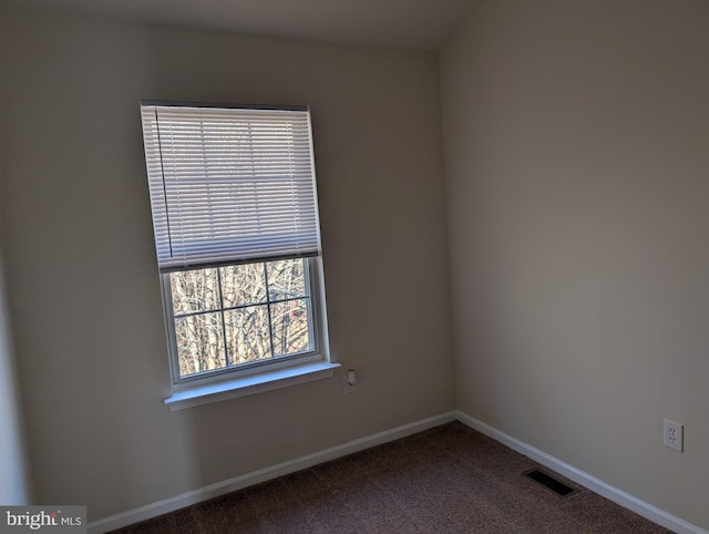 unfurnished room featuring carpet flooring, visible vents, and baseboards