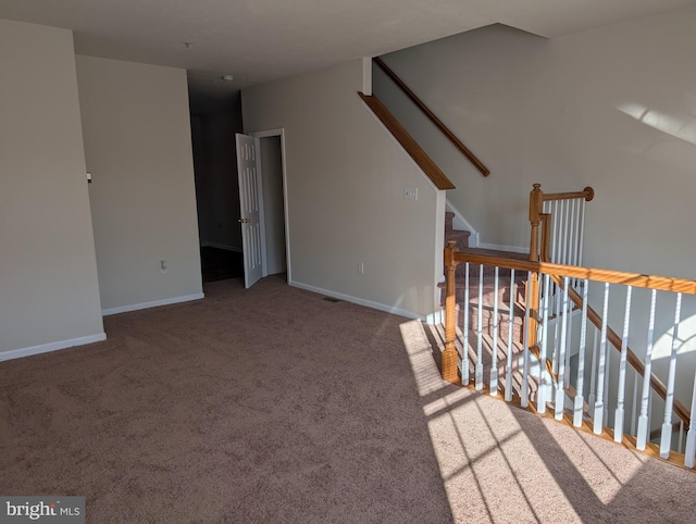 unfurnished room with stairway, carpet, and baseboards