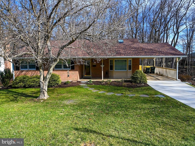 single story home with brick siding, concrete driveway, covered porch, a carport, and a front yard