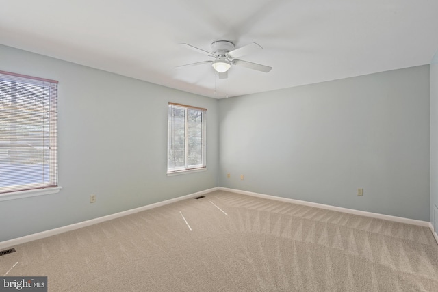 unfurnished room featuring visible vents, baseboards, carpet floors, and ceiling fan