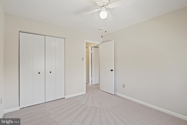 unfurnished bedroom with carpet flooring, baseboards, a closet, and ceiling fan