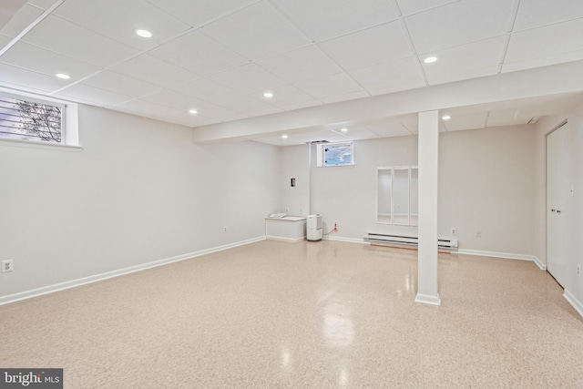 below grade area featuring recessed lighting, a paneled ceiling, baseboards, and a baseboard radiator