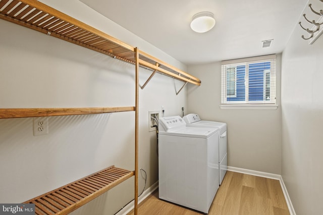 laundry room with visible vents, baseboards, washing machine and dryer, laundry area, and light wood-style floors