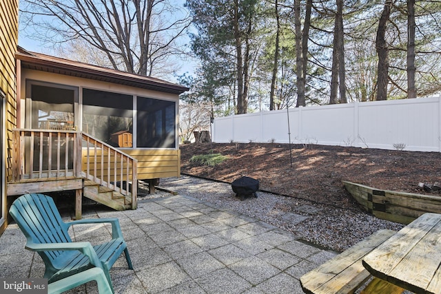 view of patio featuring fence and a sunroom