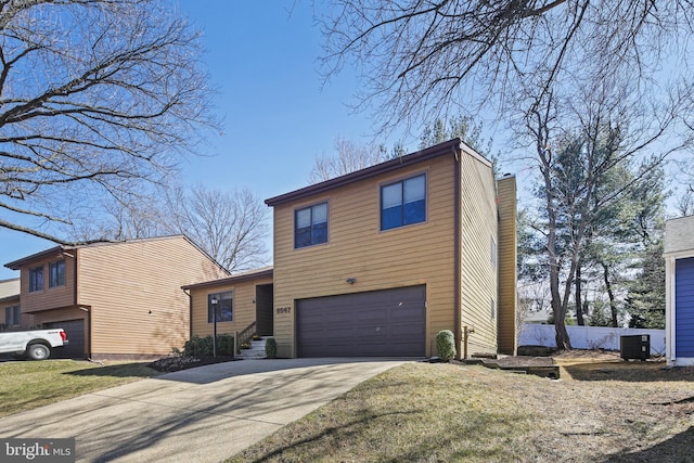 view of front of house with a garage, concrete driveway, and central AC