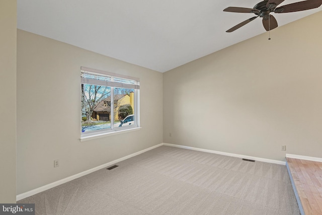 unfurnished room featuring visible vents, lofted ceiling, carpet, and baseboards