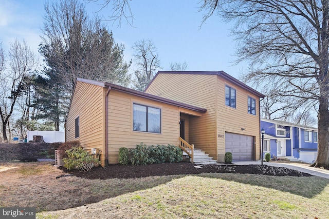 tri-level home with an attached garage, driveway, and a front lawn