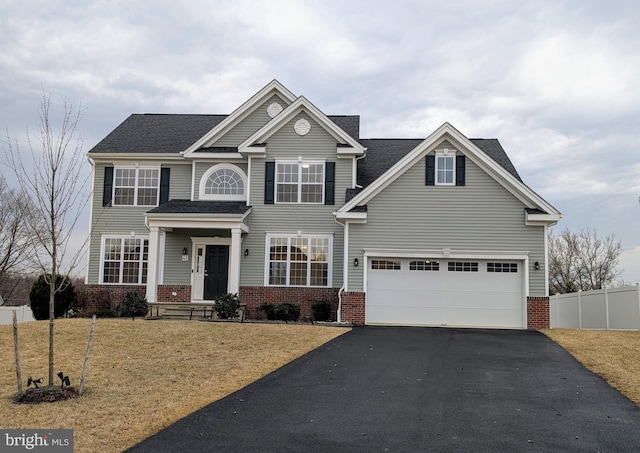 view of front of house featuring a garage, driveway, brick siding, and fence