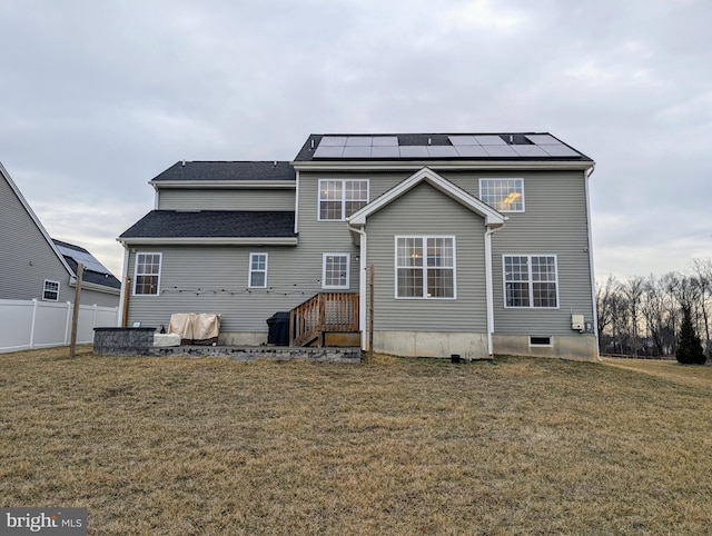 back of house featuring a yard, solar panels, and fence