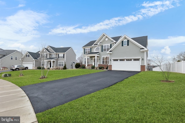 view of front facade with a residential view, aphalt driveway, fence, a front lawn, and brick siding