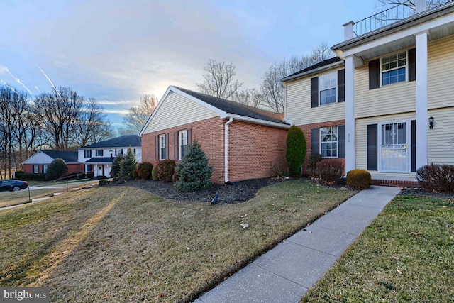 view of front of home with brick siding and a front yard