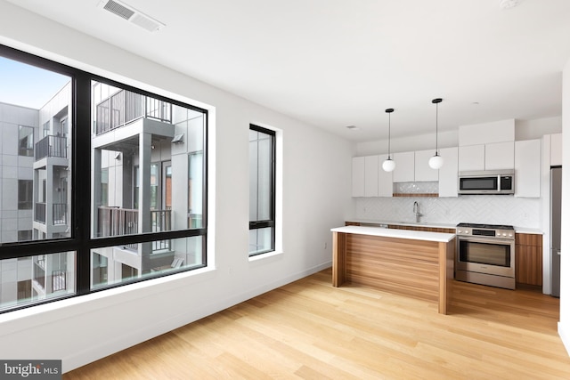 7175 12th St NW Unit 601, Washington, DC 20011 - kitchen featuring white cabinets, appliances with stainless steel finishes, decorative backsplash, and modern cabinets