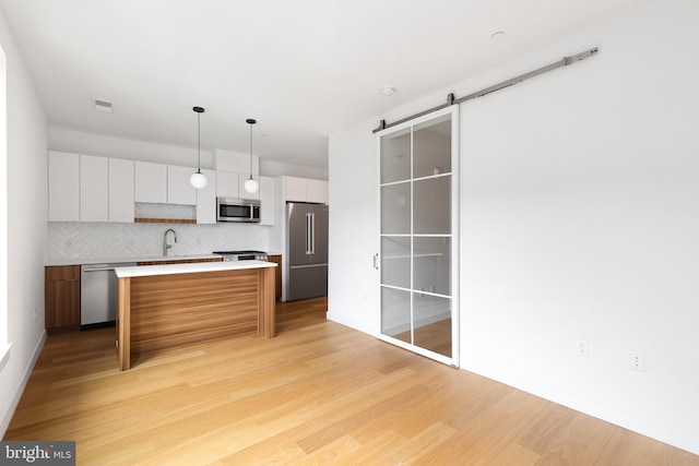 7175 12th St NW Unit 601, Washington, DC 20011 - kitchen with visible vents, decorative backsplash, white cabinets, light wood finished floors, and stainless steel appliances