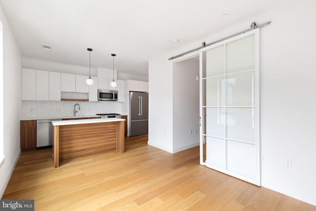 7175 12th St NW Unit 601, Washington, DC 20011 - kitchen featuring visible vents, a barn door, white cabinetry, and appliances with stainless steel finishes