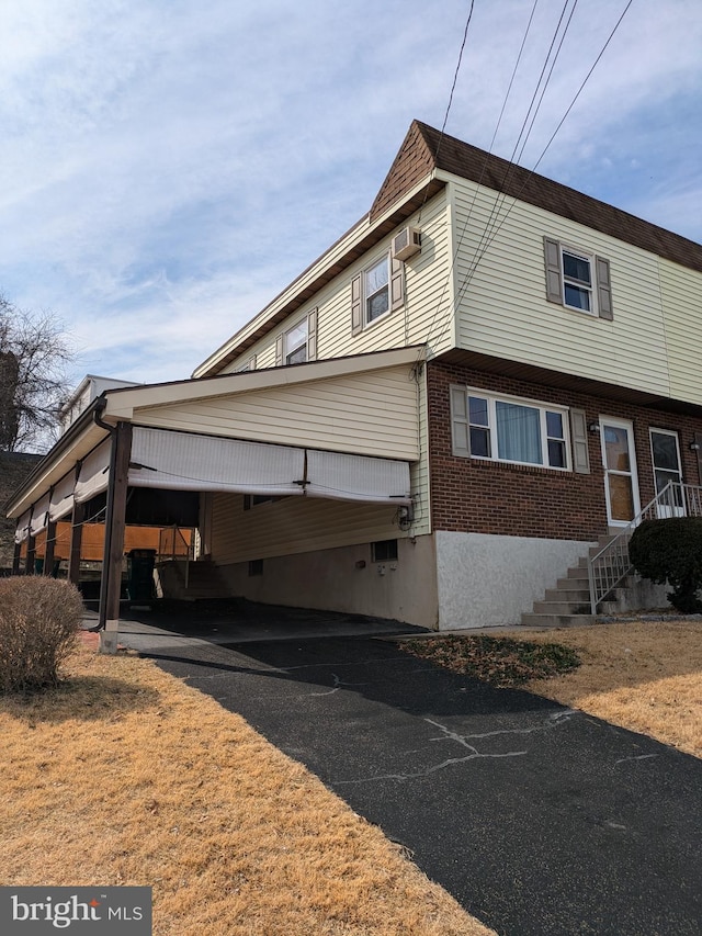 view of side of home featuring a carport and brick siding