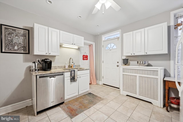 kitchen featuring light tile patterned floors, a sink, white cabinets, stainless steel dishwasher, and radiator