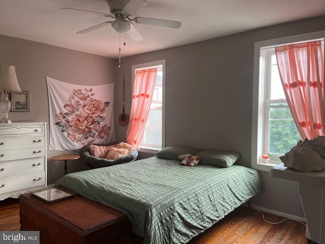 bedroom with multiple windows, wood finished floors, and a ceiling fan