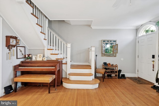 entrance foyer featuring baseboards, stairway, and wood finished floors