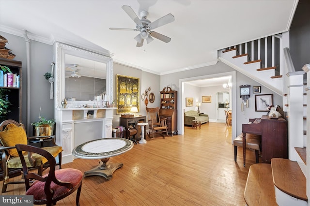 interior space with ornamental molding, a ceiling fan, and light wood-style floors