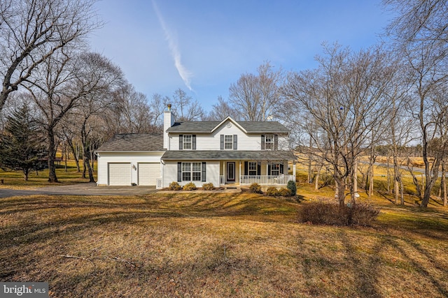 traditional-style home with a porch, aphalt driveway, a garage, a chimney, and a front yard