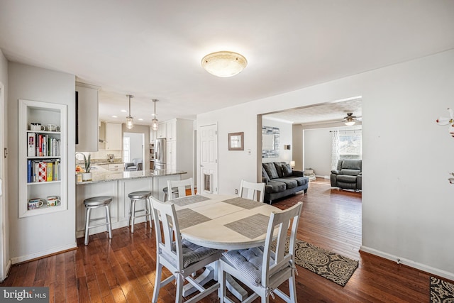 dining area featuring a wealth of natural light, baseboards, and dark wood-type flooring