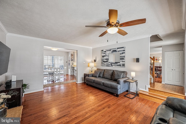 living area featuring ornamental molding, a textured ceiling, and hardwood / wood-style floors