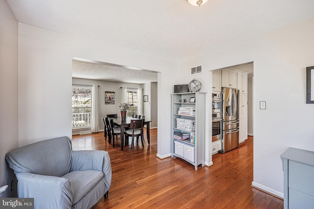 sitting room featuring baseboards, visible vents, and hardwood / wood-style floors