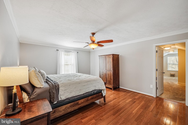 bedroom featuring hardwood / wood-style floors, ornamental molding, ceiling fan, a textured ceiling, and baseboards