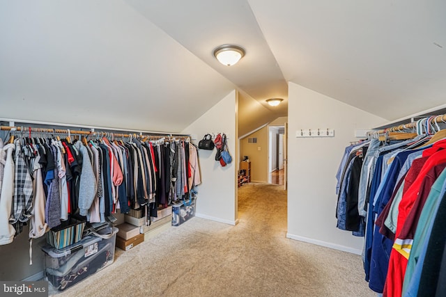 walk in closet with lofted ceiling and carpet flooring