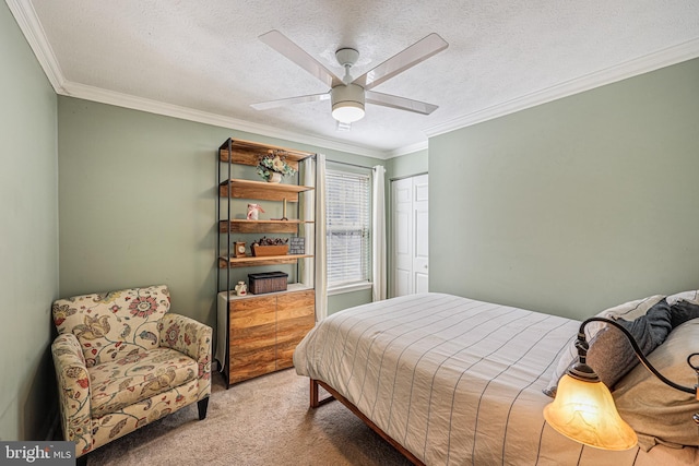 bedroom with a closet, ornamental molding, a ceiling fan, carpet flooring, and a textured ceiling