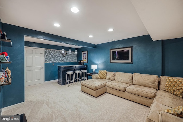 living area featuring recessed lighting, an accent wall, baseboards, a dry bar, and carpet