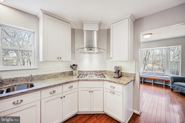 kitchen featuring dark wood finished floors, white cabinetry, stainless steel gas cooktop, and wall chimney exhaust hood