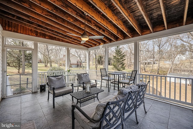 sunroom / solarium featuring beam ceiling