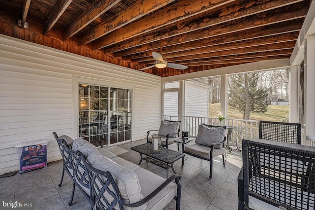 sunroom / solarium featuring ceiling fan and beam ceiling