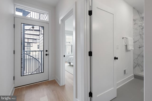 foyer entrance with light wood-type flooring and baseboards