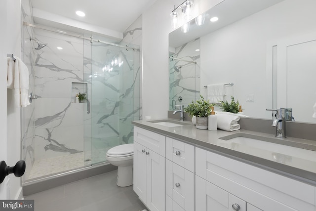 bathroom featuring a marble finish shower, a sink, and toilet