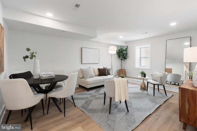 living room featuring light wood-style floors, visible vents, and recessed lighting