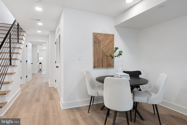 dining space with light wood-style floors, recessed lighting, stairway, and baseboards