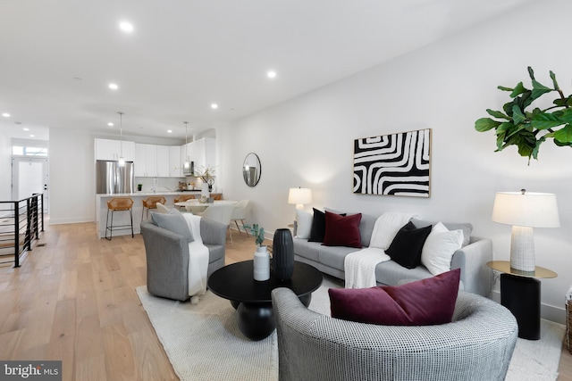 living room featuring light wood-style flooring, baseboards, and recessed lighting