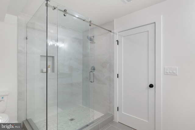 bathroom with a shower stall and toilet